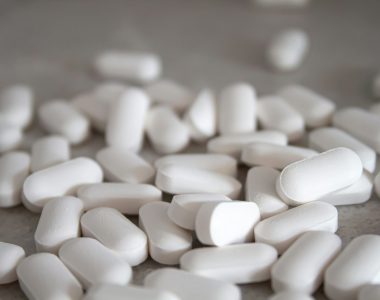 white medication pills on brown surface